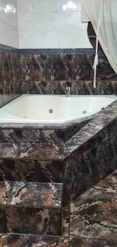 a bath tub sitting on top of a stone wall at Hostel Küyen Mapu in Comodoro Rivadavia