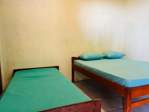 two beds in a room with blue pillows at Bunaken Scuba Guest House in Bunaken