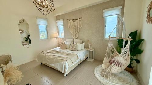 a bedroom with a bed and a hanging swing at Burano Yellow Villa in Hengchun South Gate