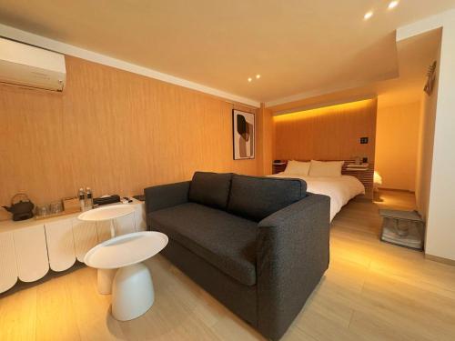 a hotel room with a couch and a bed at MKG Home・芝 in Tokyo