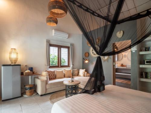 a living room with a couch and a bed at Lila Boutik Canggu in Canggu