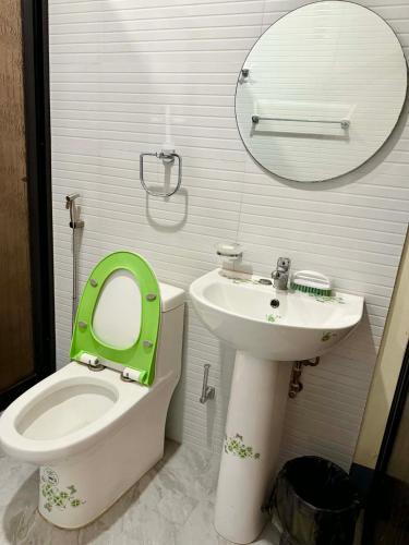 a bathroom with a green toilet and a sink at Henritz Apartelle in Sogod