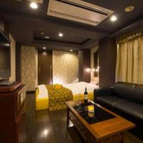 a hotel room with a bed and a couch at かぼちゃの馬車 泉大津大人専用 in Izumiotsu