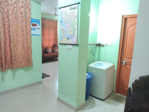 a bathroom with a toilet in a room with a door at Rich nest apartments colva in Colva