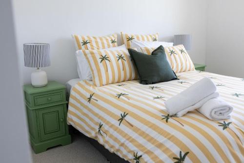 a bedroom with a bed with a green nightstand with at 2-45 Beech Street in Evans Head