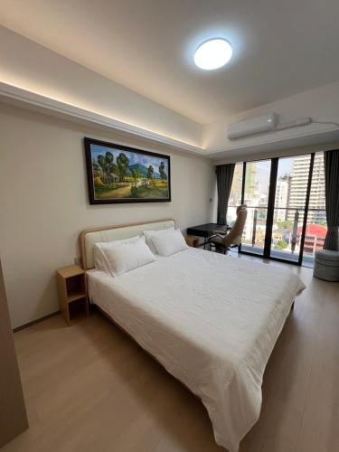 una camera da letto con un letto bianco e una grande finestra di LeConde Luxury a Phnom Penh