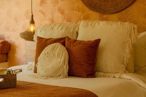 a bed with pillows on it with at Kai Villas Lombok in Kuta Lombok