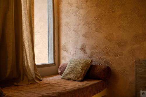 a window seat with a pillow sitting next to a curtain at Kai Villas Lombok in Kuta Lombok