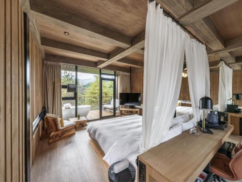 a bedroom with a canopy bed and a large window at Deer Chaser Hotel - Sun Moon Lake in Yuchi