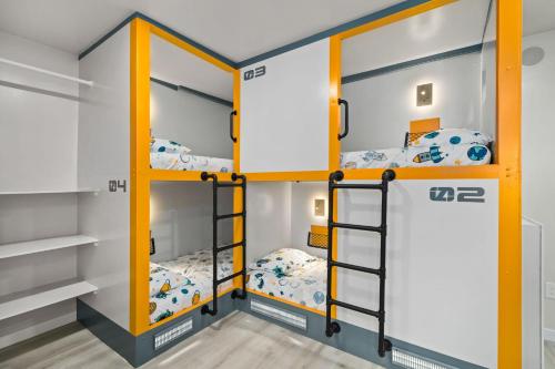 a room with three bunk beds in it at Galaxy Quest by OC Adventure Homes in Garden Grove