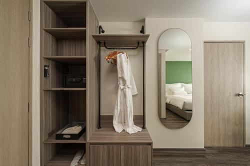 a dressing room with a mirror and a bed at The Akyra Bangkok 11 in Bangkok