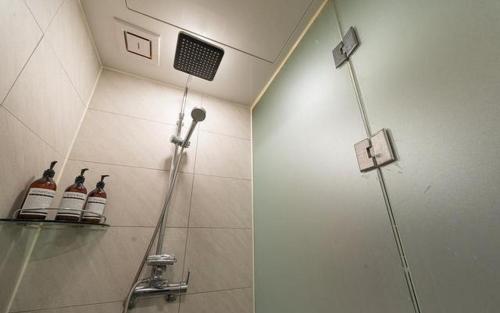 a shower in a bathroom with bottles on a shelf at ZaZaHOTEL in Sosa