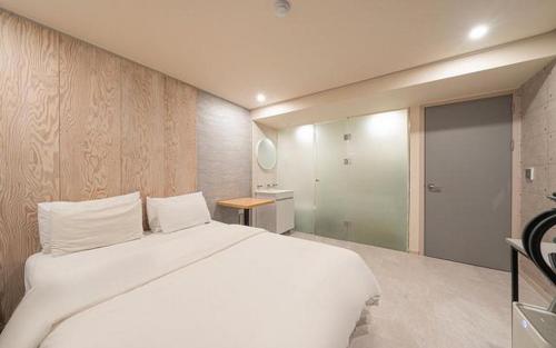 a bedroom with a large white bed and a bathroom at ZaZaHOTEL in Sosa
