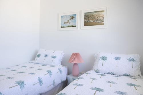a bedroom with two beds and a pink lamp at 4-45 Beech Street in Evans Head