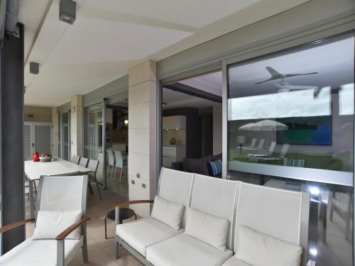 een woonkamer met witte stoelen en een tafel bij Las Barcas in San Agustin