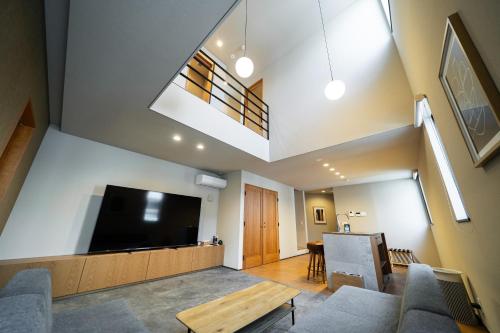 a living room with a large flat screen tv at TRIGON Hotel FUKUOKA in Fukuoka