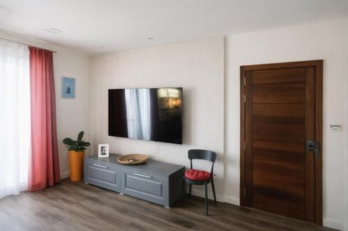 a room with a desk and a television on the wall at Stylish 2-Bedroom Apartment in Scenic Marsaxlokk in Marsaxlokk