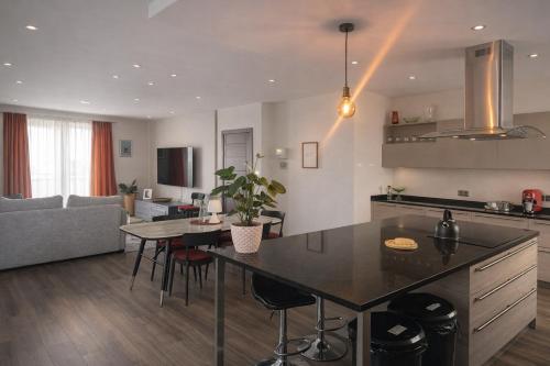 a kitchen and living room with a table and chairs at Stylish 2-Bedroom Apartment in Scenic Marsaxlokk in Marsaxlokk
