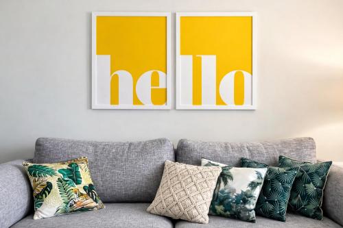 a couch in a living room with two pictures on the wall at Stylish 2-Bedroom Apartment in Scenic Marsaxlokk in Marsaxlokk