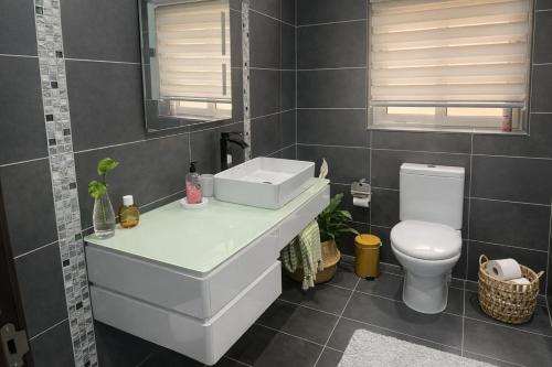 a bathroom with a white sink and a toilet at Stylish 2-Bedroom Apartment in Scenic Marsaxlokk in Marsaxlokk