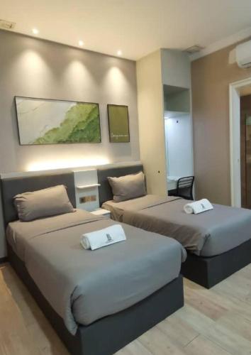 a hotel room with two beds with towels on them at BOOKME HOTEL in Johor Bahru