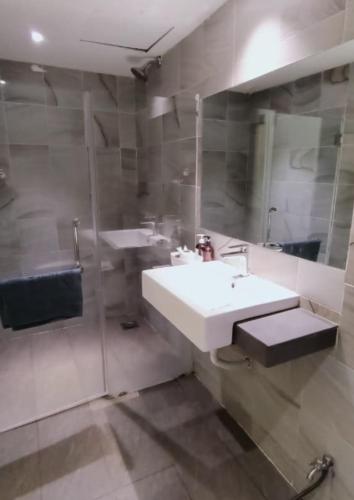 a bathroom with a white sink and a shower at BOOKME HOTEL in Johor Bahru