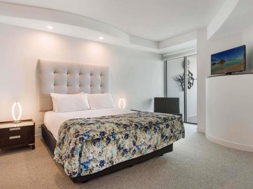 a bedroom with a large bed and a tv at Mantra Sirocco in Mooloolaba
