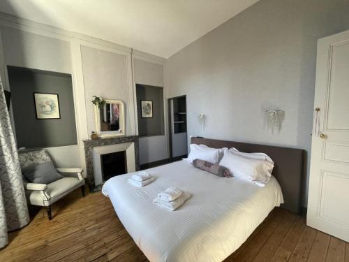 a bedroom with a bed with towels on it at Petite gare aux oiseaux in Le Châtenet