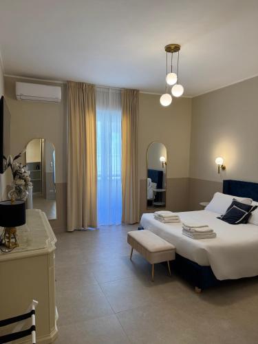 a bedroom with a large white bed and a chair at Maison ì room, suite & apartment in Reggio di Calabria