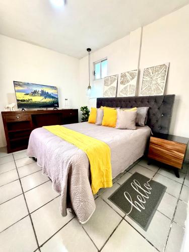 a bedroom with a bed with a yellow blanket at CASA YON SAN JUAN escapada en pareja in Cuautitlán Izcalli