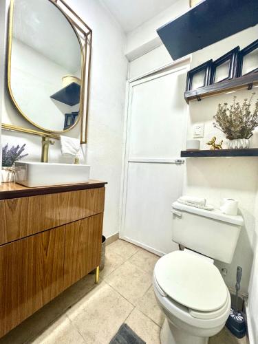 a bathroom with a toilet and a sink and a mirror at CASA YON SAN JUAN escapada en pareja in Cuautitlán Izcalli
