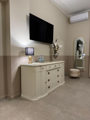 a white dresser with a television on top of it at Maison ì room, suite & apartment in Reggio di Calabria