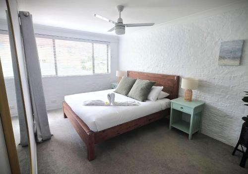 a bedroom with a bed and a nightstand with a lamp at Banksia Beach Views! in Banksia Beach