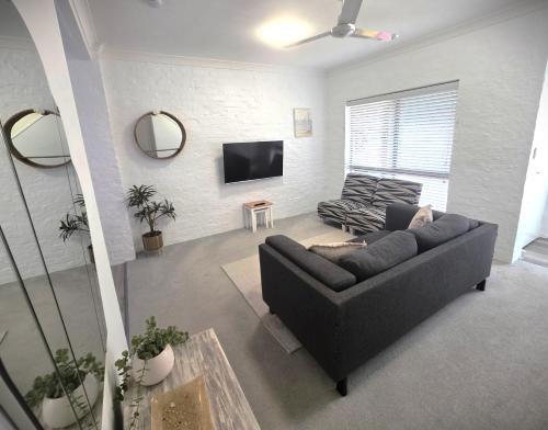 a living room with a couch and a tv at Banksia Beach Views! in Banksia Beach