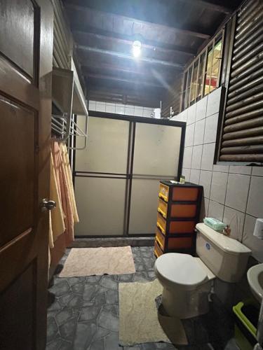 a bathroom with a toilet and a sliding door at Cabaña Río Sarapiquí in Sarapiquí