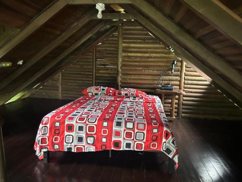 a red and white bed in a attic at Cabaña Río Sarapiquí in Sarapiquí