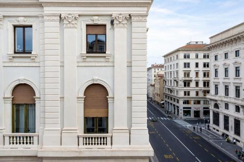 two views of a white building and a street at Hotiday Trieste Teatro in Trieste