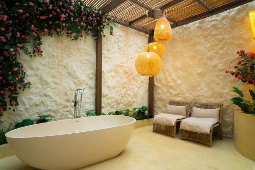 a bathroom with a bath tub and some flowers at Melon Hotel Tố Hữu in Trung Văn
