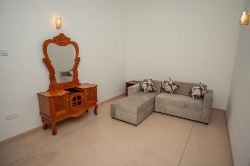 a living room with a couch and a mirror at Villa Paranawatta in Unawatuna