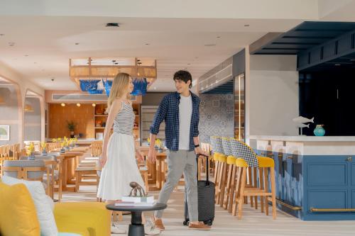 a man and a woman walking through a restaurant at ibis Styles Phuket Bangtao in Bang Tao Beach