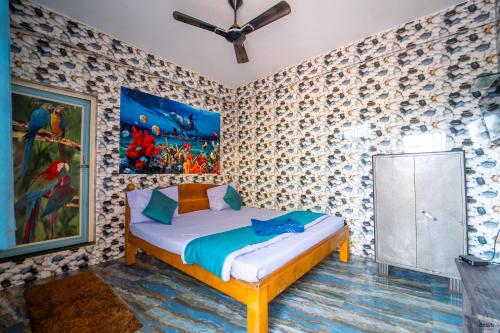 a bedroom with a bed with a painting on the wall at Marcelo Palace - Baga in Calangute
