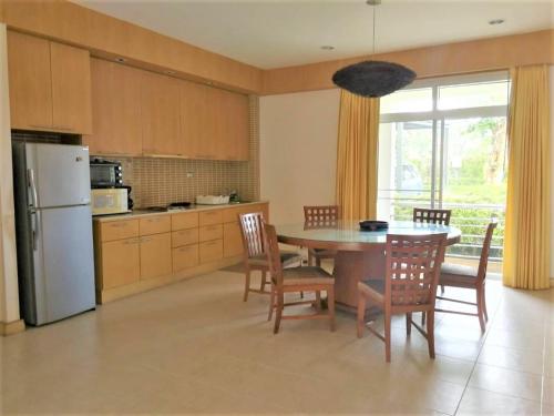 a kitchen with a table and chairs and a refrigerator at Hua Hin Blue Lagoon in Cha Am