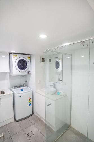 a bathroom with a sink and a washing machine at Grosvenor Beachfront Apartments Surfers Paradise in Gold Coast