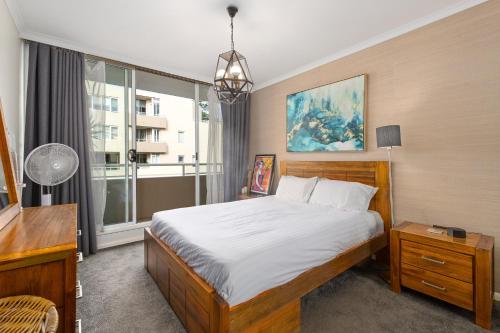 a bedroom with a bed and a large window at Spacious 1 Bed Near Manly Beach in Sydney