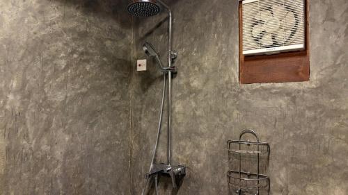 a shower in a bathroom with a shower head at The Cove Pasikuda - Eco Retreat in Pasikuda