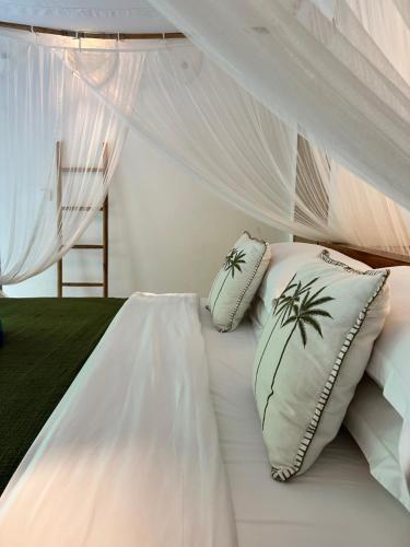a bedroom with a bed with white sheets and pillows at Santai Villas in Nusa Lembongan