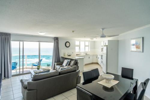 a living room with a couch and a table at Grosvenor Beachfront Apartments Surfers Paradise in Gold Coast