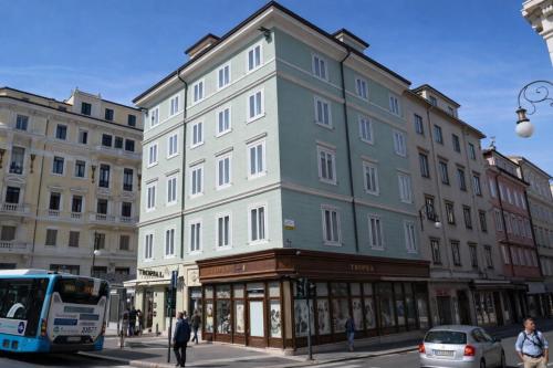 a large building on a city street with a bus at Hotiday Trieste Corso Italia in Trieste