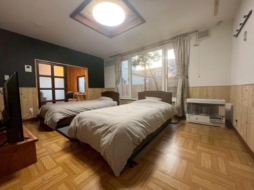 a bedroom with two beds and a large window at komorebi - Vacation STAY 19085 in Hakodate