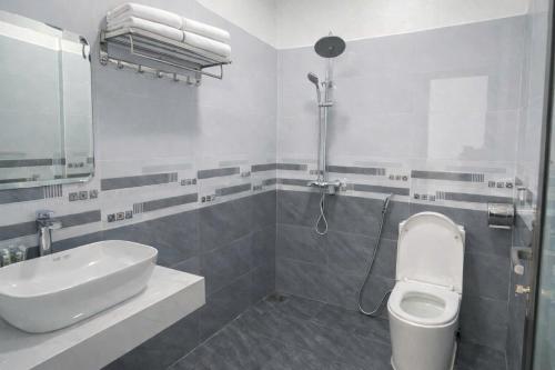 a white bathroom with a sink and a toilet at Anh Dung Homestay in Ga Thừa Lưu
